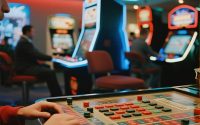 Split image of online casino gaming on a smartphone and a glamorous land-based casino floor.